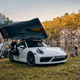 A photo of a Porsche 911 with a roof top tent fitted.